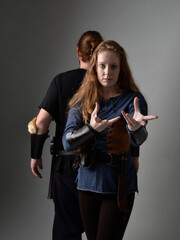 Full length  portrait of red haired  couple, man and woman wearing medieval viking inspired fantasy costumes, standing romantic intimate poses, isolated on white  studio background.