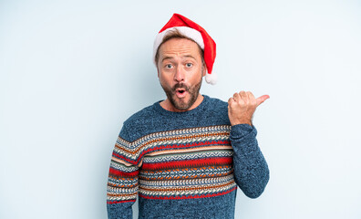 middle age handsome man looking astonished in disbelief. christmas concept