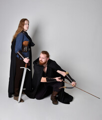 Full length  portrait of red haired  couple, man and woman wearing medieval viking inspired fantasy...