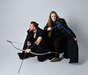 Full length  portrait of red haired  couple, man and woman wearing medieval viking inspired fantasy...