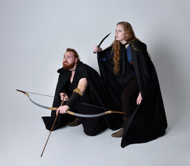 Full length  portrait of red haired  couple, man and woman wearing medieval viking inspired fantasy...
