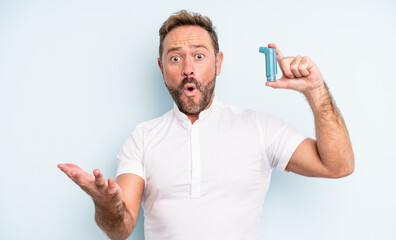 middle age handsome man amazed, shocked and astonished with an unbelievable surprise. asthma concept