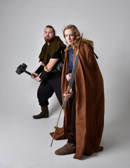 Full length  portrait of red haired  couple, man and woman wearing medieval viking inspired fantasy...
