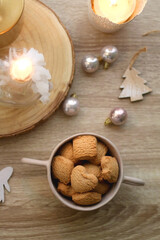 Bowl of cinnamon cookies, lit candles and various Christmas decorations on the table. Flat lay.