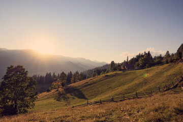 Obraz premium Morning sun shining over pasture in mountains