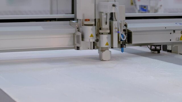 Automated technology, industrial, robotic, electronic, production, manufacturing concept. Digital cutting and creasing plotter - cnc flatbed cutter during work at factory, exhibition