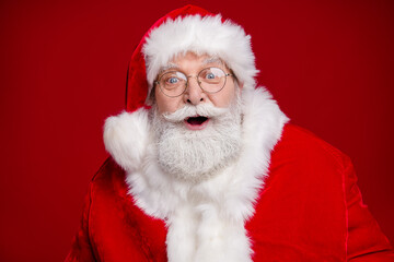 Photo of funny impressed retired man wear santa claus costume spectacles open mouth celebrating noel isolated red color background