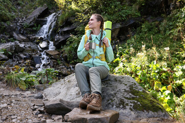 Naklejka na ściany i meble Tourist with cup near waterfall in mountains