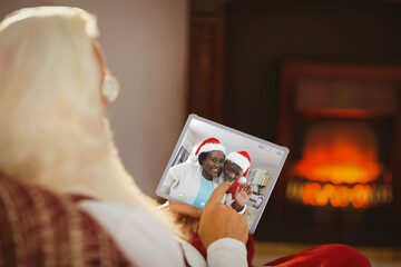 Caucasian senior woman on tablet christmas video call with smiling friends in santa hats