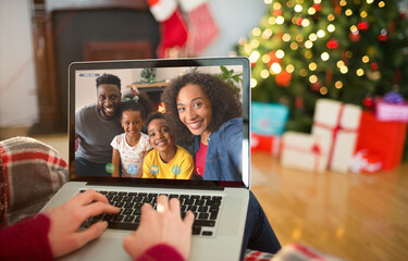 Caucasian woman on laptop christmas video call with smiling friends