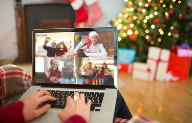 Caucasian woman making christmas laptop video call with smiling friends and family