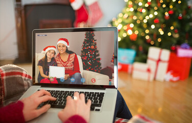 Caucasian woman making laptop christmas video call with smiling mother and daughter