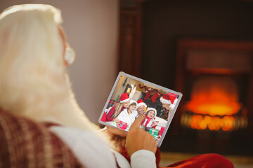 Santa claus making tablet christmas video call with smiling caucasian family