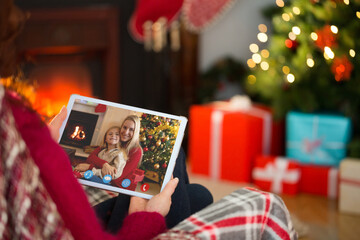 Naklejka na ściany i meble Caucasian woman on christmas tablet video call with caucasian mother and daughter