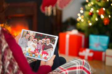 Naklejka na ściany i meble Caucasian woman on christmas tablet video call with caucasian family