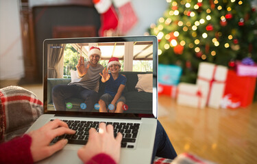 Caucasian woman on christmas laptop video call with caucasian father and son