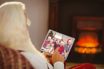 Caucasian santa claus on christmas laptop video call with caucasian family