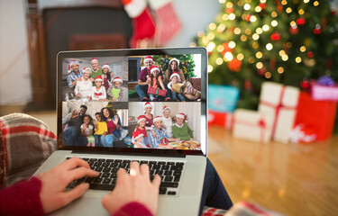 Caucasian woman on christmas laptop video call with diverse group of friends
