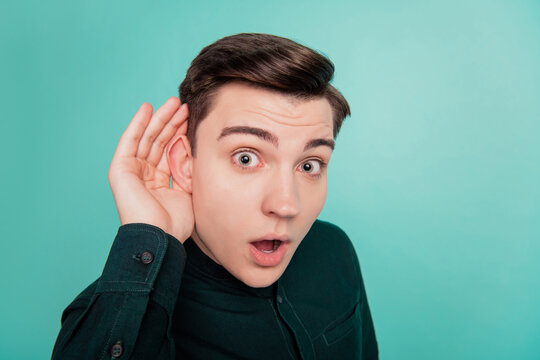 Portrait of excited crazy guy palm ear eavesdropping close look camera omg reaction on turquoise background