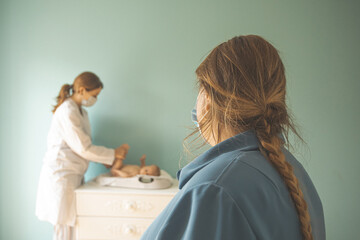 Obraz premium Baby on weight scale at the doctor