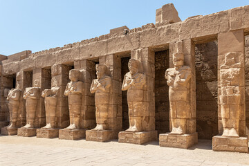 The statues of Pharaoh Ramses III as Osiris guarding the precinct of the temple of Karnak, Luxor,...