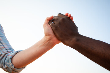 Multiracial relationship and friendsip concept. Two hands holding together.