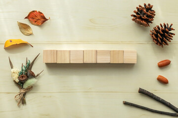 中央に木製キューブを七個並べ周りに秋の小物を並べた