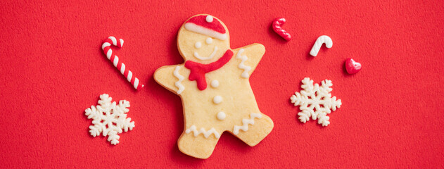 Decorated Christmas gingerbread cookies on red table background.
