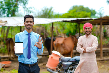 Indian agronomist showing smartphone screen with farmer