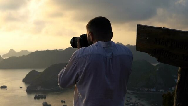Man taking photo of amazing Ha Long Bay in Vietnam during sunset