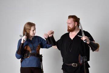 Full length  portrait of red haired  couple, man and woman wearing medieval viking inspired fantasy...