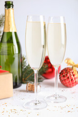 Happy New Year! Glasses of sparkling wine and festive decor on white background