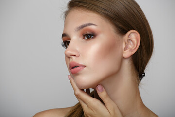 Fototapeta premium face of a beautiful woman with makeup. Touch your hands