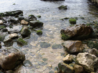 Fototapeta na wymiar Rocky beach. Stones in the water. Sea.