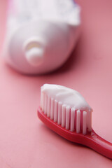 tooth brush and paste on pink 