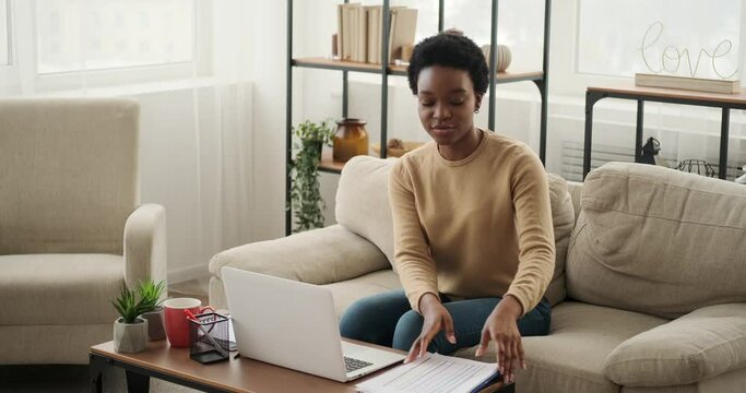 Woman discussing work by video call using laptop at home