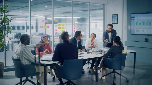 Multi-Ethnic Office Conference Room Meeting: Diverse Team of Creative Entrepreneurs, Specialists Talk, Use TV for infographics. Businesspeople work on Digital e-Commerce Startup. Static Wide Shot