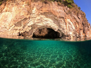 Fototapeta na wymiar Underwater split photo of paradise sea cave arch with crystal clear emerald sea in Mediterranean destination island