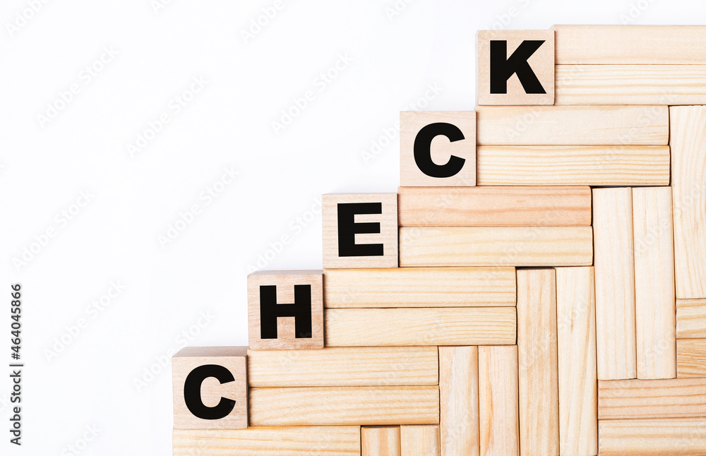 Poster on a light background, wooden blocks and cubes with the text check