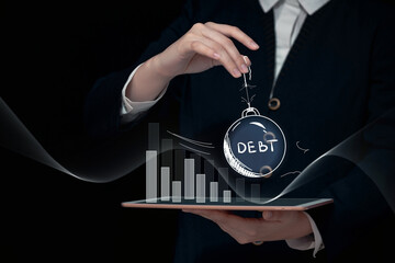debt crisis concept, weight with the inscription debt in hand over a bar graph, default and bankruptcy background, huge corporate and external debt,