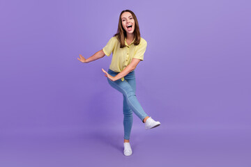 Fototapeta na wymiar Full length photo of funky young brunette lady dance wear yellow top jeans shoes isolated on purple color background