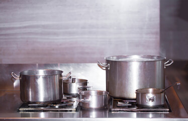 Pots on the stove cooking in a restaurant. Kitchen interior. Cooking food.