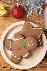 Traditional christmas gingerbread cookies over a wooden table with gift box christmas decoration