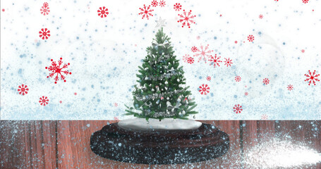 Image of snow falling and glowing spots over snow globe with tree on white background