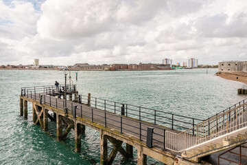 Fototapeta na wymiar A man (unidentifiable) watching for boats from Victoria Pier at the Entrance of Portsmouth Harbour