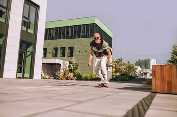 Smiling excited man enjoying his skateboarding workout