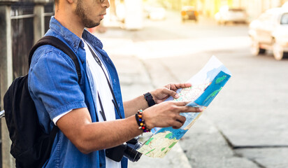 man from behind looking at a map looking for a location. travel and tourism concept.