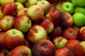 Red and green apples on the counter. Bright juicy fruits. Health and vitamins from nature. Close-up. Selective focus.