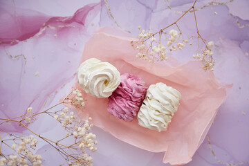 Feminine background, pink and white marshmallow with decoration of gypsophila close up. Cozy winter weekends. Homemade sweets. Top view. Copy space