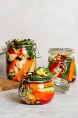 Fermented vegetables in glass jars. Fermented preserved vegetarian food. Homemade canned food concept. Various pickled vegetables.